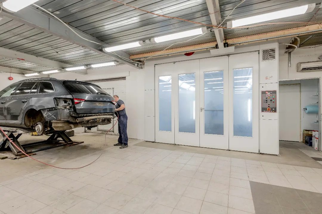 Technician working on a vehicle in a collision repair bay